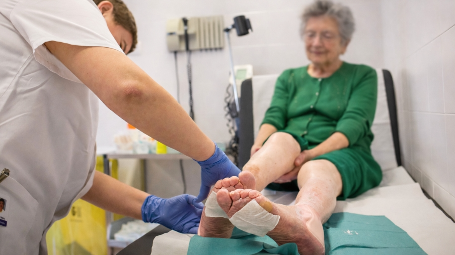 Enfermero curando una señora mayor.